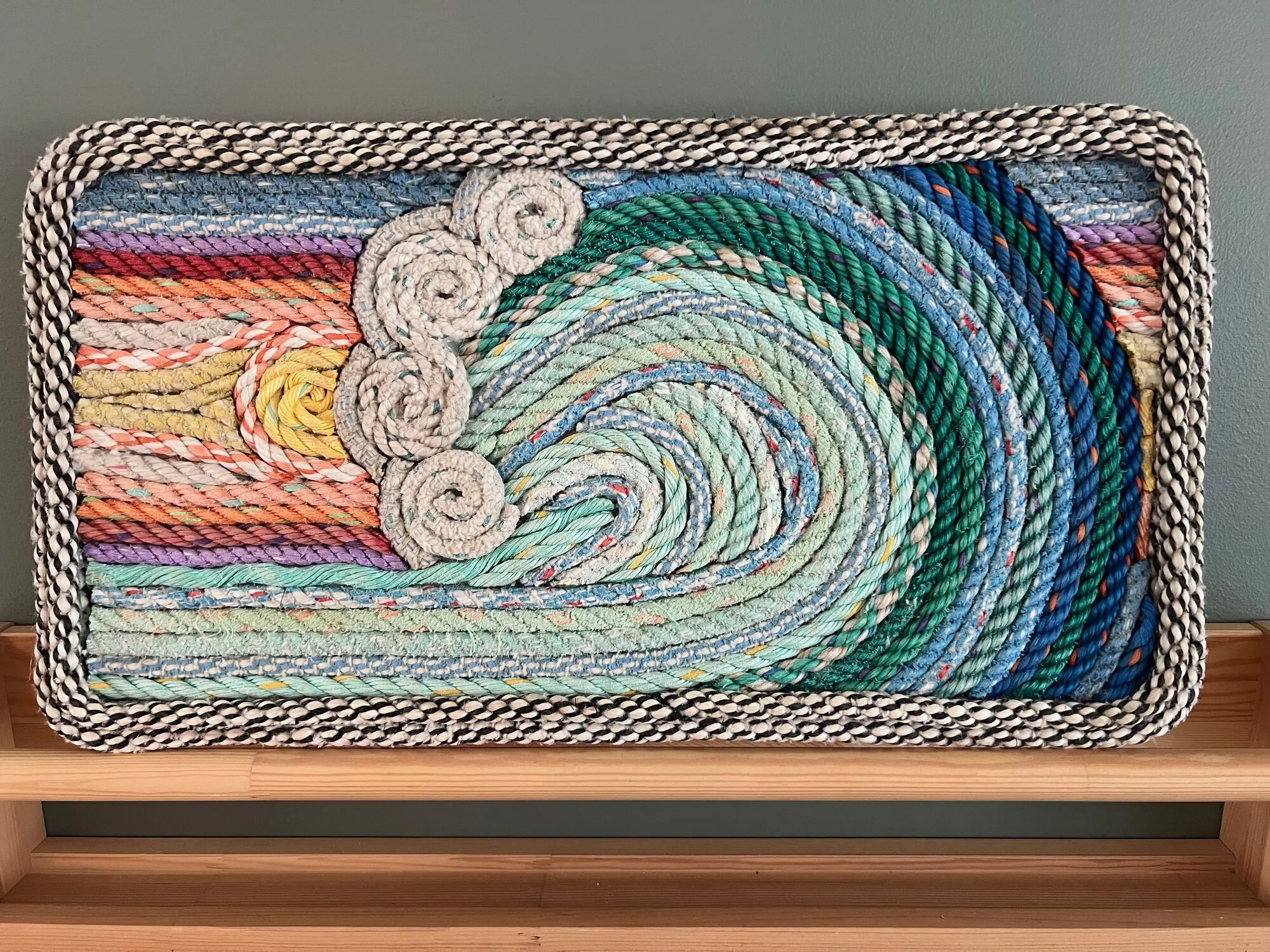 Framed rope wall art of a curling ocean wave